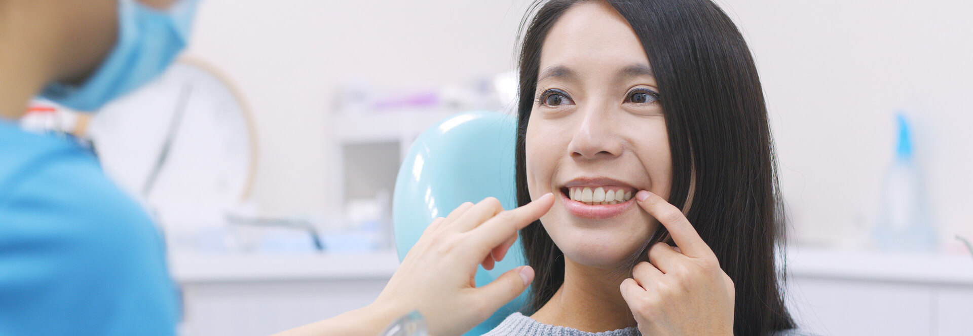 Woman pointing at her teeth to show dental implants
