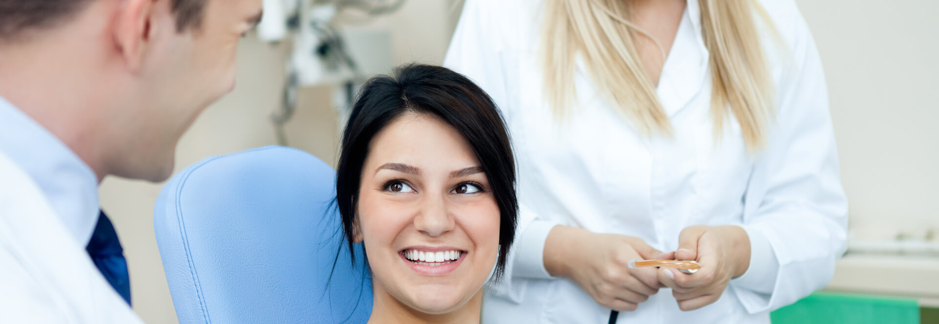 Smiling female patient receiving dental treatment