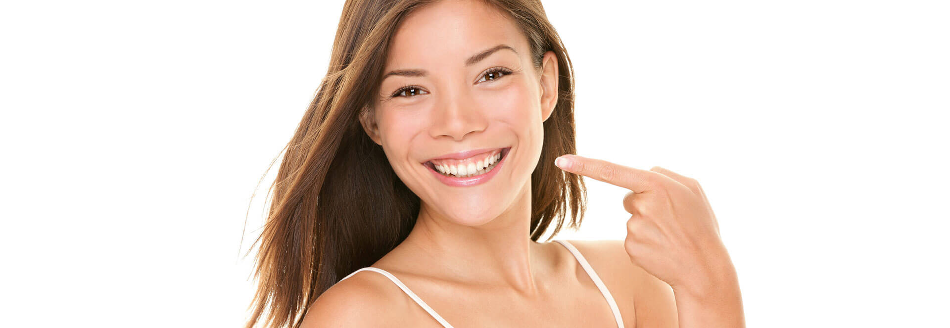 Happy young woman smiling pointing at her tooth colored fillings